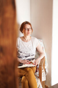 Petra sitzt auf ihrem Schreiblesesessel im Kreativlabor Erlangen